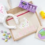 DIY Easter Bag for Kids -- this project is too fun with the patterned iron on vinyl and pom pom trim! From overthebigmoon.com!